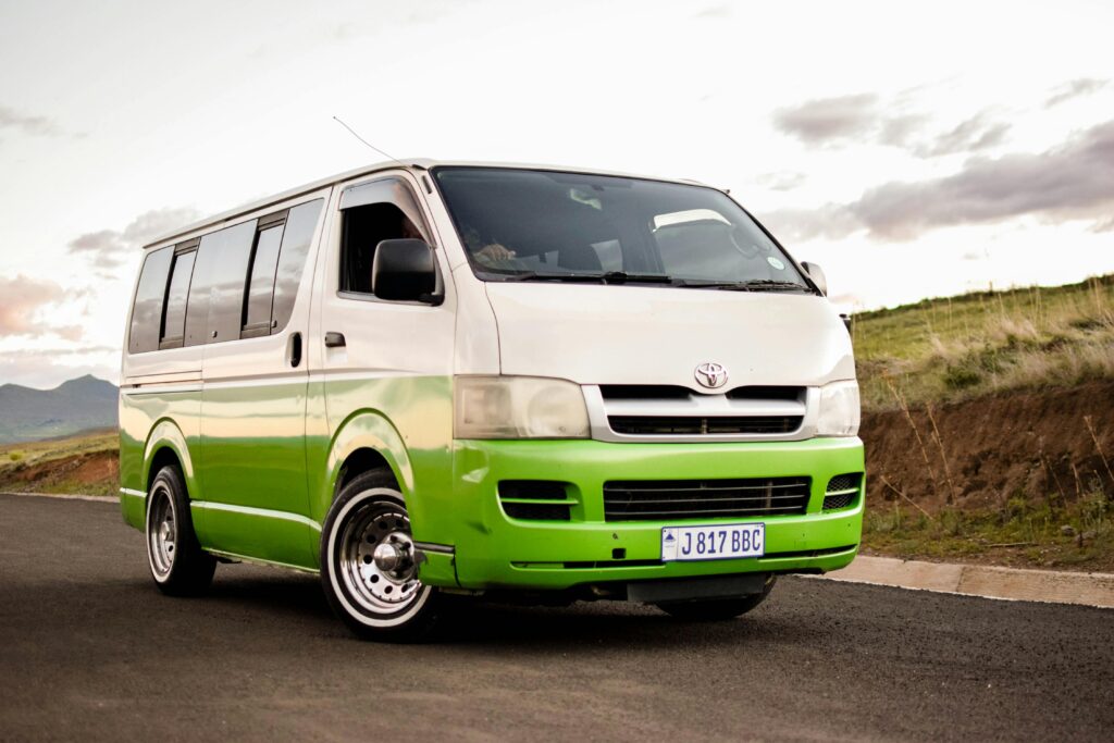 A colorful Toyota HiAce van on a scenic road, ideal for travel and transportation themes.